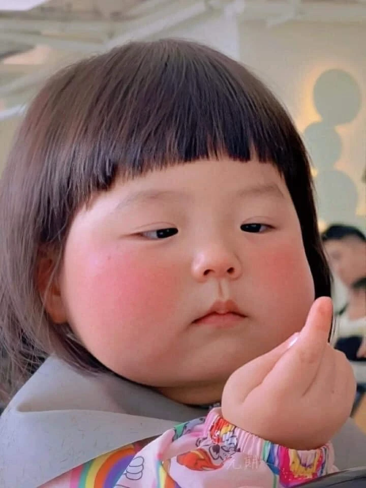 Chubby baby kid girl looking at her finger